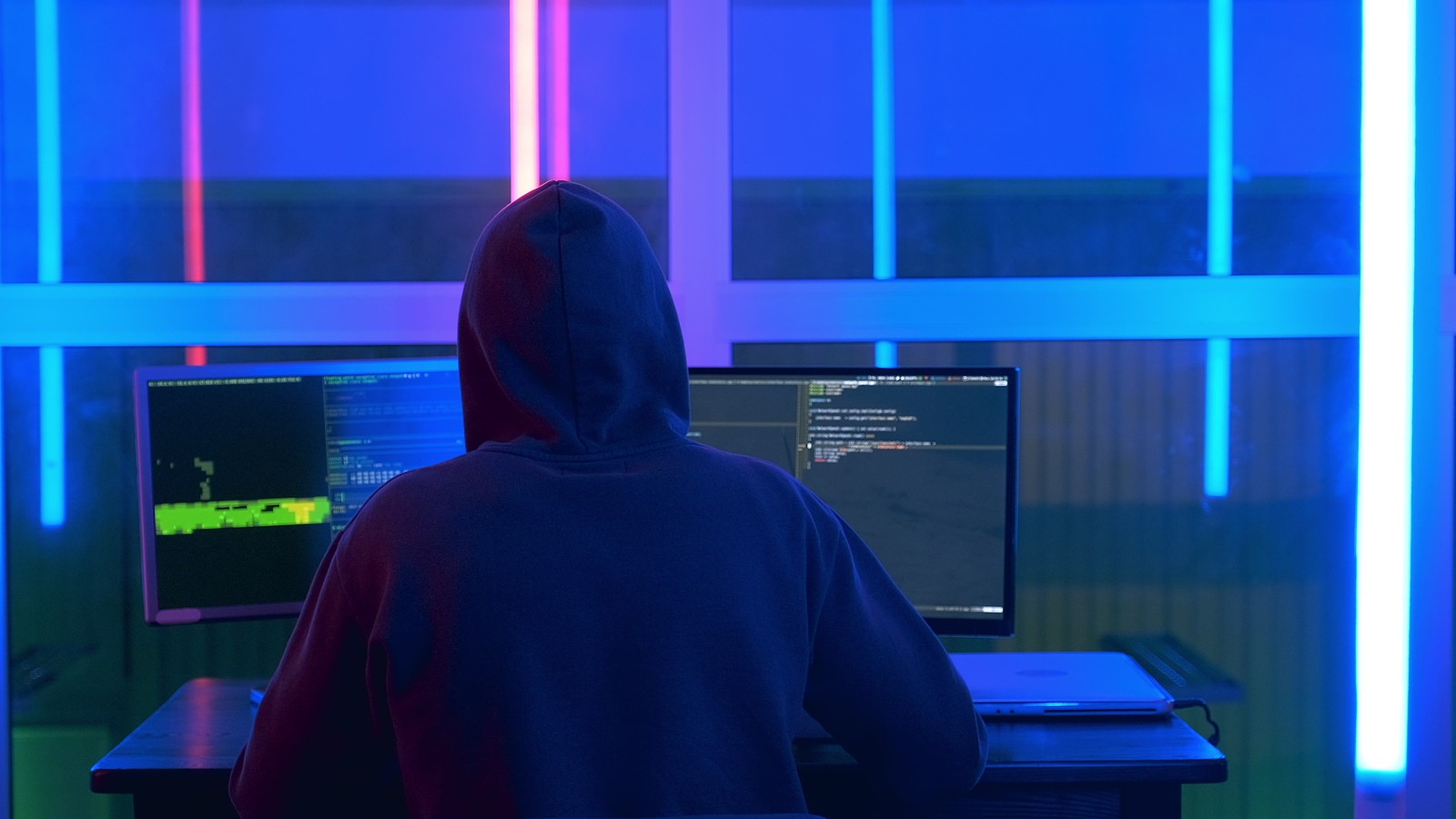 Back view of hacker in a black jacket